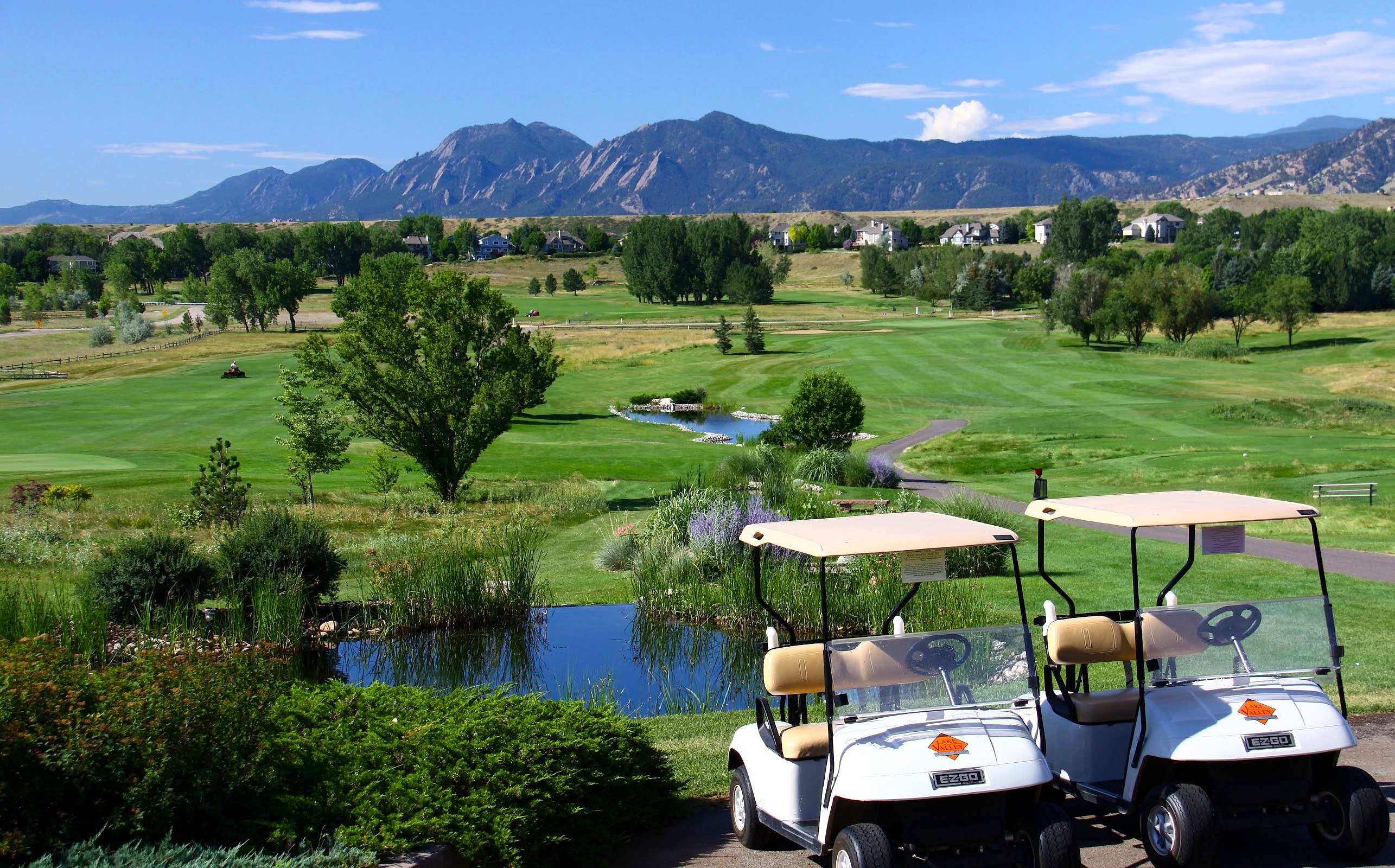 Two golf carts overlooking the Lake Valley course with water hazards and mountain views